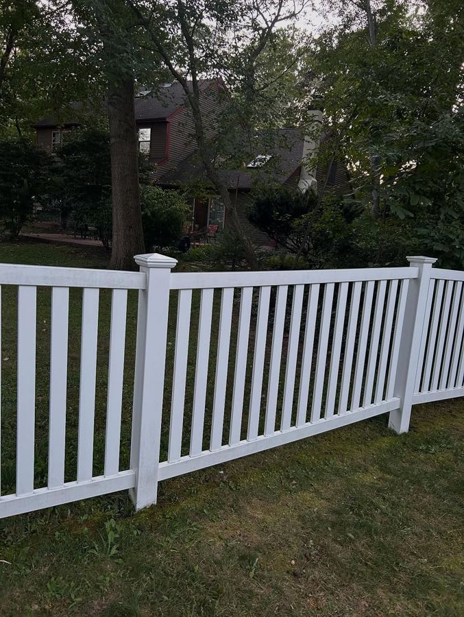 Bright white vinyl fence after power washing