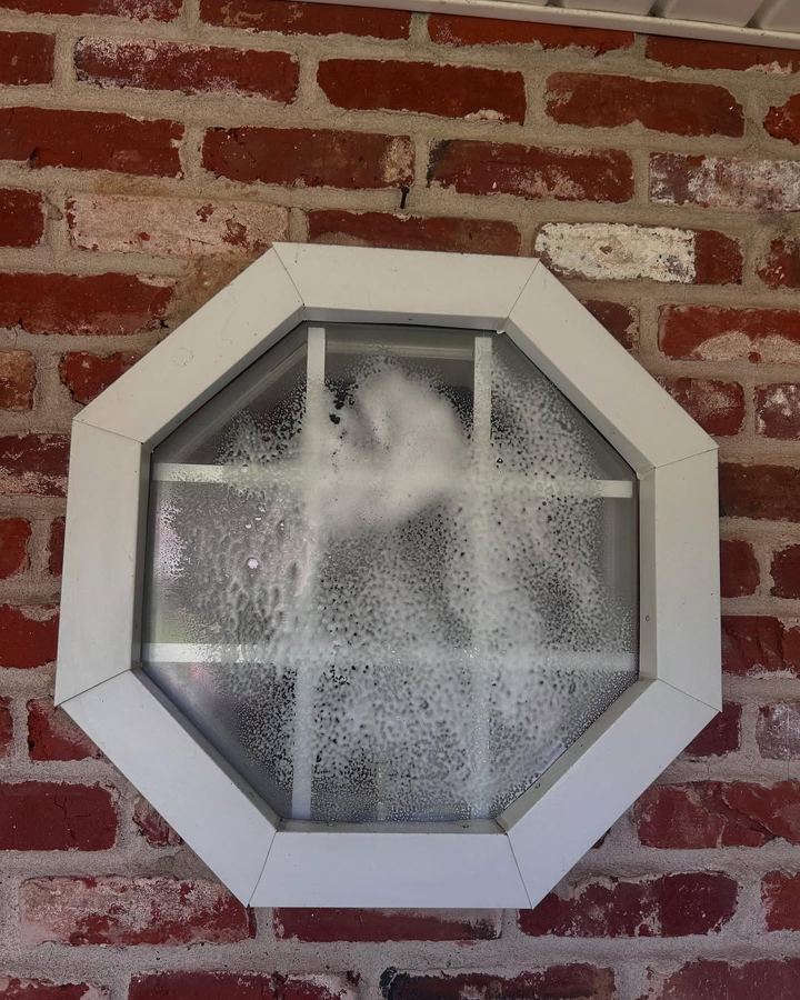 Same octagon window covered in grime before cleaning